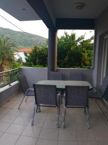 a patio with a table and chairs on a balcony at Grey House in Prinos