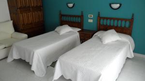 um quarto com duas camas e uma cadeira num quarto em Hostal La Paz em Vista Alegre