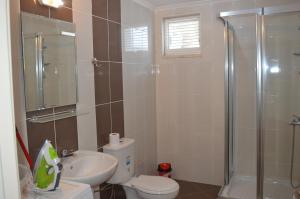 een badkamer met een douche, een toilet en een wastafel bij Sultan Homes Apartments 2 in Kemer
