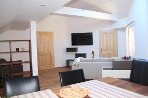 salon z kanapą i stołem z krzesłami w obiekcie Ferienwohnung Grimmingblick w mieście Bad Mitterndorf