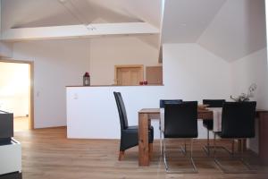 jadalnia ze stołem i czarnymi krzesłami w obiekcie Ferienwohnung Grimmingblick w mieście Bad Mitterndorf