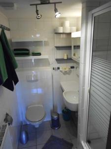 a white bathroom with a toilet and a sink at Haus Droste in Husum