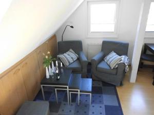 uma sala de estar com duas cadeiras e uma mesa de centro em Haus Droste em Husum