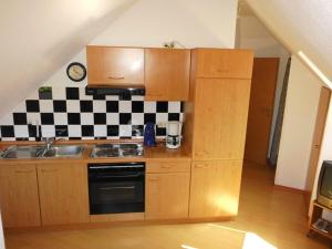 a kitchen with wooden cabinets and a sink and a stove at Haus Droste in Husum
