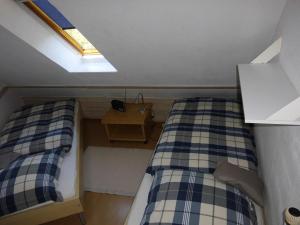 a small room with two beds and a skylight at Haus Droste in Husum