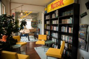 a room with a library with chairs and books at Hôtel Les Hauts de Meursault in Meursault