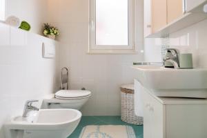 ブロダリツァにあるApartmani Nadaの洗面台とトイレを備えた白いバスルーム +49枚の写真