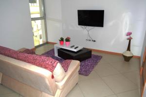 een woonkamer met een bank en een tv bij Apartamento Cristina in Praia