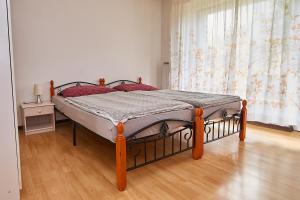 ein Schlafzimmer mit einem Bett in einem Zimmer mit einem Fenster in der Unterkunft Emona Apartments in Ljubljana