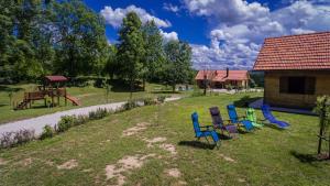 a group of chairs sitting in the grass in a yard at House Marijana in Rakovica