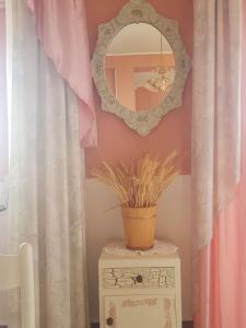un espejo en una pared sobre una mesa con una planta en B&B Mirasol, en Scalea