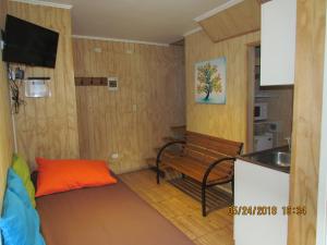 a kitchen with a bench and a sink in a room at Cabañas Entre Parques in Osorno