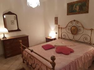 a bedroom with a bed with two red pillows on it at Villa Lory Albinia in Albinia