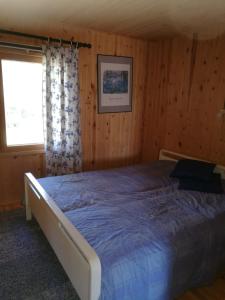 1 dormitorio con 1 cama en una habitación de madera en ILO107 en Huhus