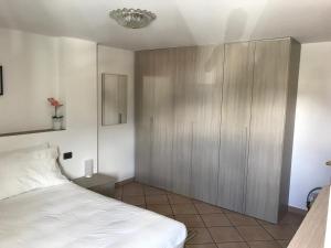 1 dormitorio con 1 cama y armario de madera en casa vacanze nicoletta, en Aosta
