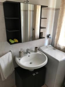 a bathroom with a white sink and a mirror at casa vacanze nicoletta in Aosta