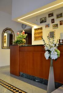a lobby with a reception desk with a vase of flowers at Hotel Luana in Rimini