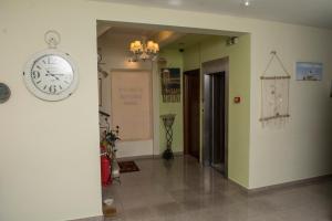 a hallway with a clock on the wall at Dionysos Rooms in Olympiaki Akti