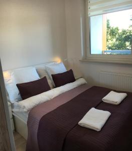 a bedroom with a large bed with two towels on it at Apartamenty Metro Słodowiec, free parking Żeromskiego 1 CMKP- 5 min in Warsaw