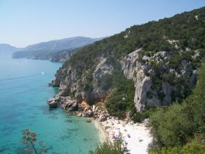 einen Strand mit Leuten am Wasser in der Unterkunft Estate in Ogliastra Sa figumoru 5 minuti al mare in Bari Sardo