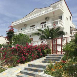 a white house with stairs and flowers in front of it at Summer Dreams in Ksamil