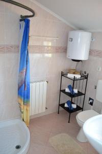a bathroom with a shower curtain and a toilet at Apartments Marko in Poreč