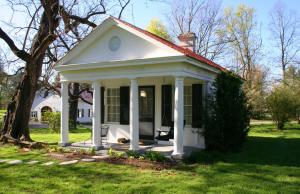 una pequeña casa blanca con techo rojo en Historic Rosemont Manor, en Berryville