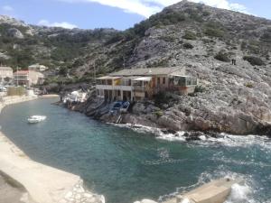 a house on a rocky hill next to the water at "Lou Pataquet" in Marseille +13 photos