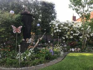 a garden with flowers and a butterfly on a fence at Ferienwohnung Hage in Hage +1 photo