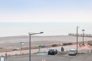 um parque de estacionamento com carros estacionados junto à praia em Le Galet de Mers em Mers-les-Bains