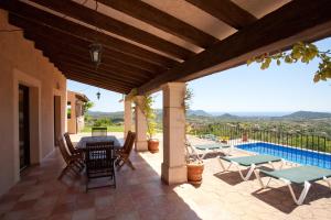 Un patio con mesa y sillas y una piscina. en El Cel (Der Himmel), en Son Servera