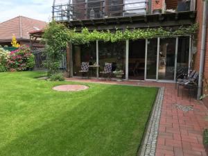 a yard with green grass and a patio at Ferienwohnung Hage in Hage