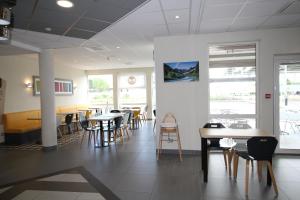 une salle à manger avec des tables et des chaises dans un restaurant dans l'établissement B&B HOTEL Valence TGV Romans, à Alixan