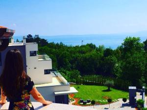 a woman standing on top of a building looking at a garden at Apartments Villa Bare in Kastav