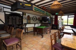 a room with a pool table and some chairs at Climbers Inn in Glencar