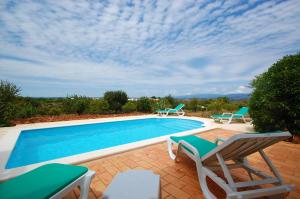 - une piscine avec 2 chaises et une table dans l'établissement Casa da Eira - Private Villa - pool - Free wi-fi - Air Con, à Silves