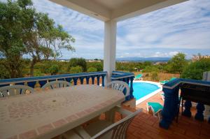a porch with a table and chairs and a pool at Casa da Eira - Private Villa - pool - Free wi-fi - Air Con in Silves