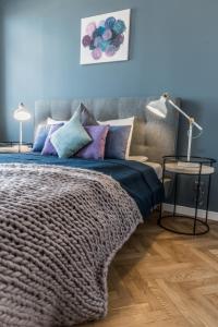 a bedroom with a bed with purple and blue pillows at Greystone Suites & Apartments in Riga