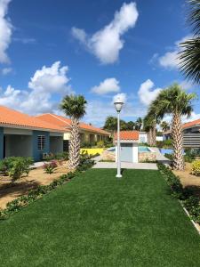 a yard with palm trees and a house at Blije Rust in Blue Bay