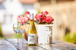 a bottle of wine and a wine glass on a table at U Roberta in Mrągowo