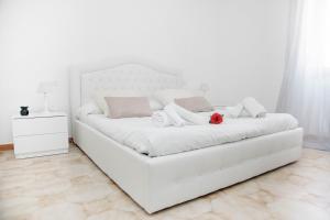 a white bed sitting in a room next to a wall at Casa Marzia Affittacamere in Alghero