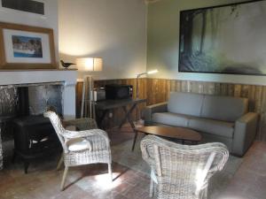 Saint-Paterne-RacanにあるLa Conciergerieのリビングルーム(ソファ、椅子、暖炉付)