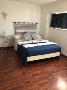 a bedroom with a large bed with a blue blanket at Blue Apartment in Pescara