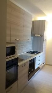 uma cozinha com armários de madeira e um forno com placa de fogão em Appartamento Salina Bamba em San Teodoro