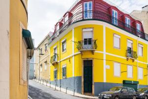 リスボンにあるEstefânia Apartment - Lisbon Center (NEW)の通路脇の黄色い建物
