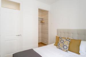 リスボンにあるEstefânia Apartment - Lisbon Center (NEW)のベッドルーム(白いベッド、黄色い枕付)