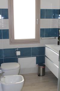 Un baño con inodoro, lavabo y ventana. en Casa Vacanze Calabro', en SantʼAntìoco 14 fotos más