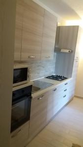 uma cozinha com armários de madeira e um forno com placa de fogão em Appartamento Salina Bamba em San Teodoro