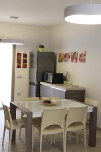 eine Küche mit einem Tisch und Stühlen sowie einem Kühlschrank in der Unterkunft Casa Vacanze Calabro' in SantʼAntìoco