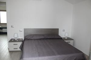 ein Schlafzimmer mit einem großen Bett mit zwei Nachttischen in der Unterkunft Casa Vacanze Calabro' in SantʼAntìoco
